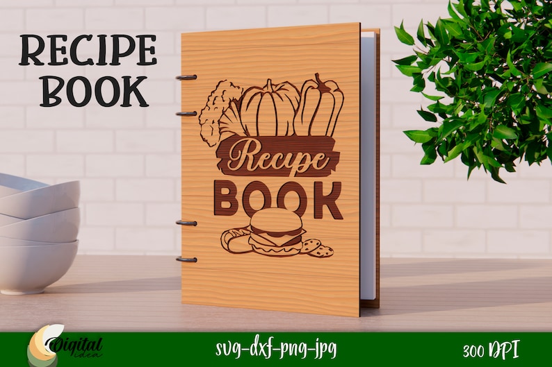 Może przedstawiać: Drewniana książka kucharska z brązową okładką i wzorem warzyw, hamburgera i tekstem "Recipe Book".