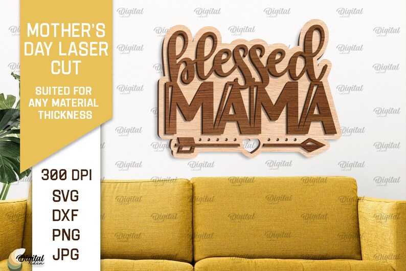 以下が含まれることがあります： 木製の看板に「Blessed Mama」という文字が茶色の木目調の文字で書かれています。看板は白い壁に黄色いソファの上に置かれています。