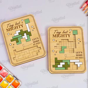 May include: Two wooden puzzle pieces with the text "Tiny but Mighty" and a pixelated design. The pieces have a light brown color with green and white accents. The text "Let's make it fit!" is also included.