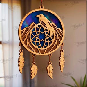 Peut inclure: Attrape-r&ecirc;ves en bois avec un motif d'oiseau et de montagne. Le cadre circulaire pr&eacute;sente un fond bleu et violet, avec un oiseau perch&eacute; au-dessus d'une cha&icirc;ne de montagnes. Trois plumes en bois pendent en dessous. Convient &agrave; toutes les &eacute;paisseurs de mat&eacute;riau.