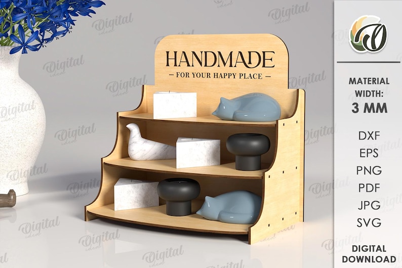 May include: A three-tiered wooden display shelf with the text "HANDMADE - FOR YOUR HAPPY PLACE." The shelf holds decorative items, including white cubes, gray cat figurines, and black mushroom-shaped objects. The material width is 3 mm.