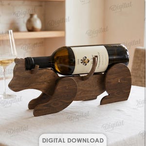 Peut inclure: Un porte-bouteille de vin en bois en forme d'ours, tenant une bouteille de Chardonnay. Le support est en bois brun foncé et repose sur une nappe blanche. Un verre à vin est visible en arrière-plan.