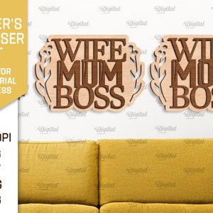 以下が含まれることがあります： 明るい木製の背景に、茶色の文字で「Wife Mum Boss」と書かれた木製の看板2つ。看板は花柄で囲まれています。