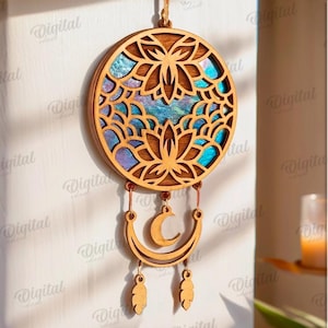 Peut inclure: Attrape-r&ecirc;ves en bois avec un motif floral et un pendentif en forme de croissant de lune. Le cadre rond en bois pr&eacute;sente un motif de fleur de lotus d&eacute;coup&eacute; au laser avec un centre iris&eacute; color&eacute;. Deux breloques en forme de plumes pendent en dessous.
