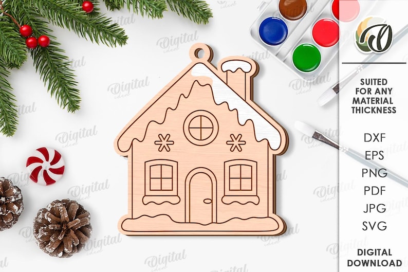 May include: A wooden gingerbread house ornament with a chimney, windows, and door. The ornament is surrounded by Christmas decorations, including pine needles, berries, and a candy cane. The text "SUITED FOR ANY MATERIAL THICKNESS" is visible.