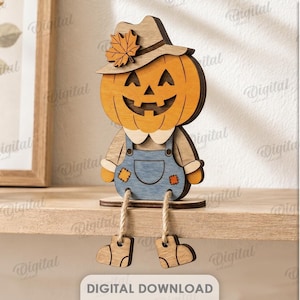 May include: A wooden pumpkin scarecrow figure with a carved jack-o'-lantern face, wearing a hat with a maple leaf and blue overalls. The figure has dangling rope legs and feet, with a material width of 3 inches. Text includes DIGITAL DOWNLOAD.