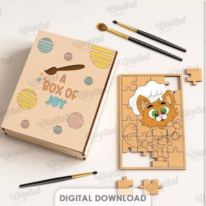 May include: A wooden jigsaw puzzle with a cartoon cat in a chef's hat, and the words "A BOX OF JOY" on the box. The puzzle is partly put together. Paintbrushes and paint are also visible. The material width is 3 mm.