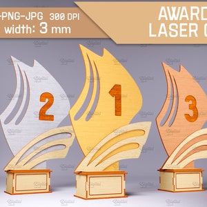 Könnte beinhalten: Drei Holz-Pokale mit Segeldesign. Die Pokale sind in Gold, Silber und Braun lackiert. Die Pokale sind mit 1, 2 und 3 nummeriert. Die Pokale sind 3 mm dick und für den Laserschnitt geeignet.