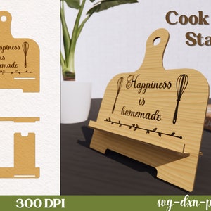 May include: A wooden cookbook stand with a cutout design. The stand features the text "Happiness is homemade" and two whisk designs. The stand is made of natural wood and has a rustic look.