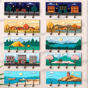 May include: A set of ten wooden key holders, each with a different landscape design. The designs include cityscapes, rural scenes, and coastal views. The key holders have multiple hooks and are 3 mm in width. The text says '10 DESIGNS'.