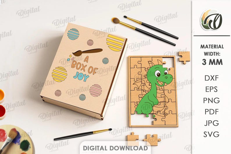 May include: A wooden box with the text "A BOX OF JOY" and a cartoon dragon puzzle. The box has colorful circles and a paintbrush design. Paintbrushes and a palette are also visible. The puzzle is 3 mm wide.