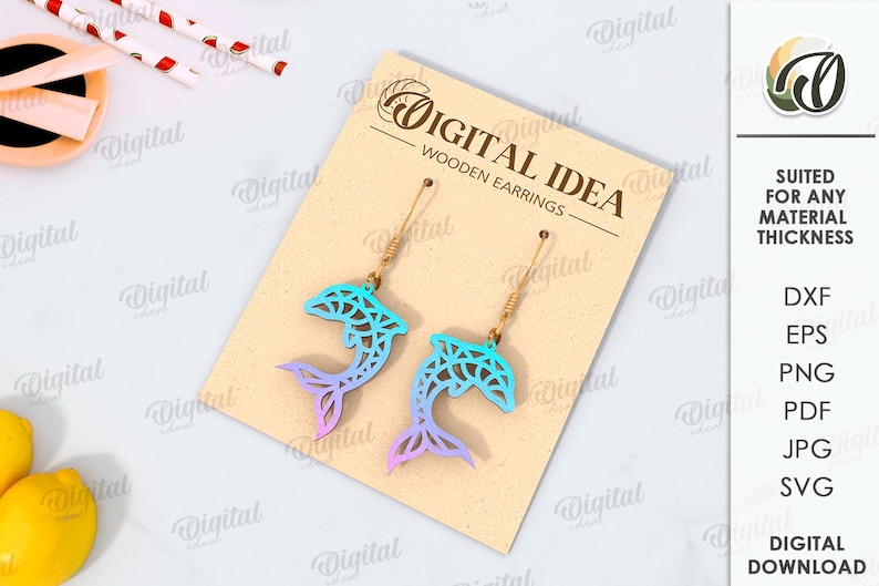 May include: A digital download of a pair of wooden earrings featuring a blue and green gradient dolphin design. The earrings are suitable for any material thickness. The file formats included are DXF, EPS, PNG, PDF, JPG, and SVG.