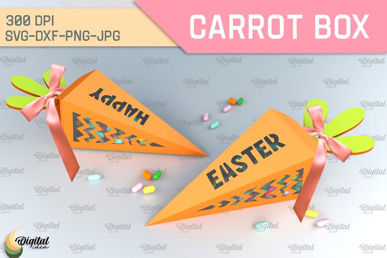Pode incluir: Duas caixas de cor laranja em forma de cenoura com janelas recortadas e as palavras "Happy" e "Easter" nelas. As caixas est&atilde;o cheias de doces coloridos e t&ecirc;m topos verdes com fitas cor-de-rosa.
