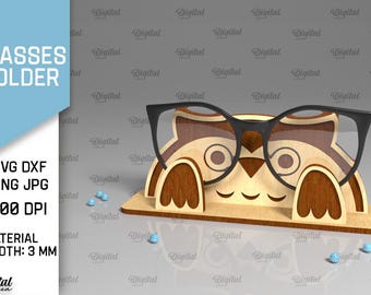 Könnte beinhalten: Ein Brillenhalter aus Holz in Form eines Waschbären, der eine Brille trägt. Der Waschbär hat braunes Fell, schwarze Augen und eine weiße Nase. Die Brille ist schwarz mit runden Gläsern. Der Halter ist 3 mm dick.