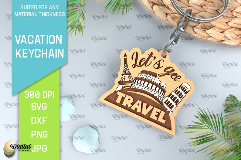 May include: Wooden keychain with a brown background and the text "Let's go travel" in white. The keychain features a silhouette of the Eiffel Tower, the Colosseum, and the Leaning Tower of Pisa.
