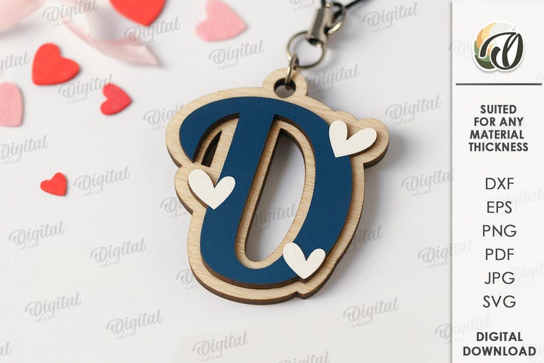 May include: A wooden letter "D" pendant with a navy blue center and light wood border, adorned with three white heart accents. The pendant hangs from a silver-colored chain. Scattered around are red and pink heart-shaped decorations.