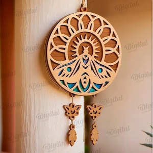 Peut inclure: D&eacute;coration murale en bois circulaire avec un motif de soleil et un insecte stylis&eacute; au centre. Des accents bleus et des pendentifs en forme de papillon et de feuille sont suspendus. Le texte indique "SUITED FOR ANY MATERIAL THICKNESS".