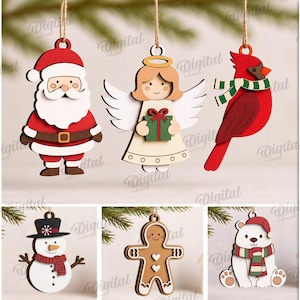 Op de afbeelding: Een set van tien houten kerstornamenten met ontwerpen van de Kerstman, een engel, een kardinaalvogel, een sneeuwman, een peperkoekmannetje, een ijsbeer, een rendier, een eekhoorn, een vogel en een kerstbal met patroon, voorzien van ophanglusjes.