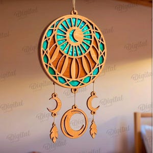 Peut inclure: Un attrape-r&ecirc;ves en bois avec un design circulaire, pr&eacute;sentant une palette de couleurs turquoise et marron. L'attrape-r&ecirc;ves comporte des pendentifs en forme de croissant de lune et de plumes. Le texte "SUITED FOR ANY MATERIAL THICKNESS" est visible.