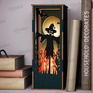 May include: A dark green wooden Halloween-themed lantern with a silhouette of a scarecrow, a full moon, and a bat. The lantern is 3 mm wide and has a digital download option.