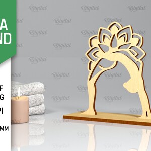 Peut inclure: Une d&eacute;coupe en bois d'une pose de yoga avec un motif de fleur de lotus. La d&eacute;coupe a une &eacute;paisseur de 3 mm et est con&ccedil;ue pour la d&eacute;coupe au laser. L'image comprend le texte "YOGA STAND" et "SVG DXF PNG JPG 300 DPI MATERIAL WIDTH: 3 MM".