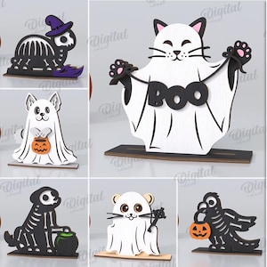 May include: A collection of Halloween-themed wooden cutouts in various designs, including a cat ghost holding a "BOO" sign, a skeleton cat with a jack-o'-lantern head, and a dog dressed as a ghost. The designs are black and white with orange accents. The text "10 DESIGNS" is visible.