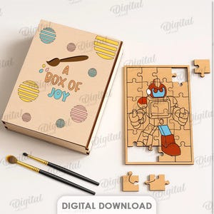 May include: A wooden puzzle and box set. The box is light brown with colourful circles and the text "A BOX OF JOY". The puzzle is a robot design. The material width is 3 mm.