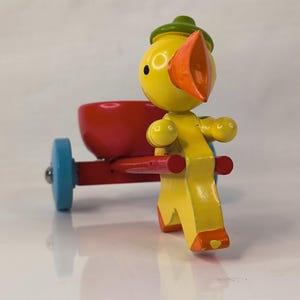 Chick pulling cart egg cups made of wood turned hand painted and with grooved wheels turning