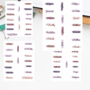 May include: Printable Bible header stickers with the text "BIBLE HEADER PRINTABLES" at the top. The stickers feature various book names from the Bible in a handwritten font, with watercolor brushstroke accents in shades of purple and pink.