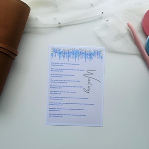 Peut inclure: Une carte blanche avec le mot "Waiting" en &eacute;criture cursive et un motif floral bleu. La carte contient un texte inspirant de la Bible. La carte est sur une surface blanche avec un fond en tissu transparent.