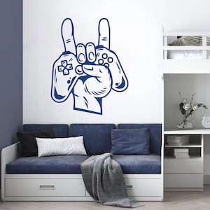 May include: A blue wall decal of a hand holding a video game controller with the index finger and pinky finger extended in a rock and roll hand gesture.