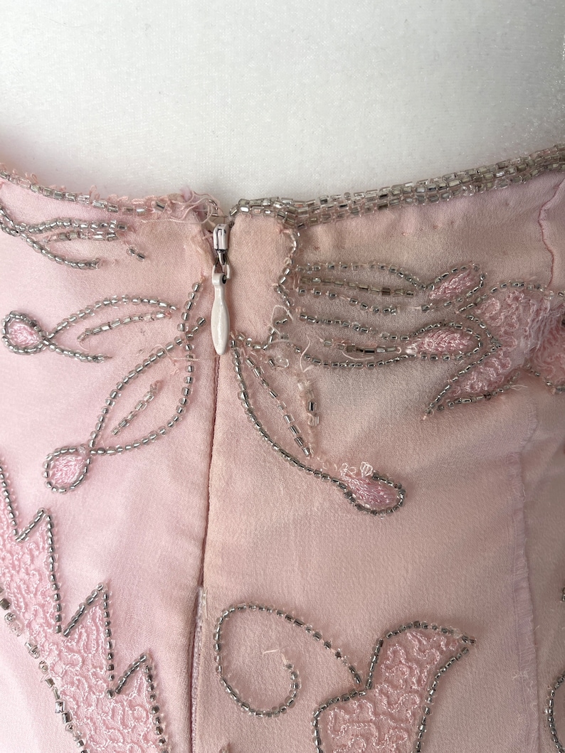 May include: A pink dress with silver beading and a zipper in the back.