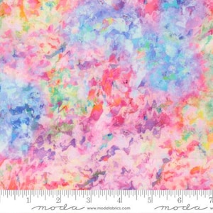 May include: A fabric swatch featuring a vibrant, abstract watercolor pattern with blended hues of pink, blue, yellow, and orange. A white ruler is visible at the bottom edge, showing measurements in inches up to 7 inches for scale.