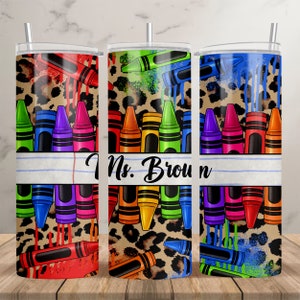 Puede incluir: Tres vasos de acero inoxidable con fondo de estampado de leopardo y dise&ntilde;os de crayones coloridos. El vaso del medio tiene el texto "Ms. Brown" sobre un fondo rayado blanco y azul.