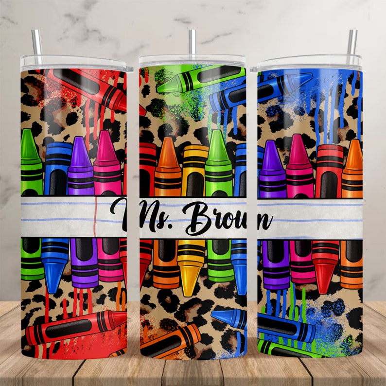 Puede incluir: Tres vasos de acero inoxidable con fondo de estampado de leopardo y dise&ntilde;os de crayones coloridos. El vaso del medio tiene el texto "Ms. Brown" sobre un fondo rayado blanco y azul.