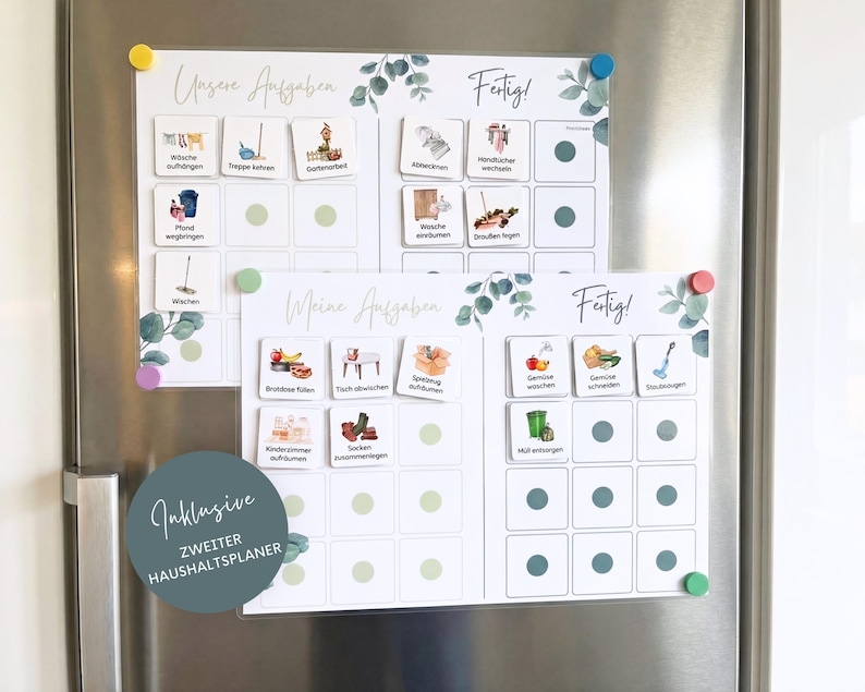May include: Two white magnetic chore charts with eucalyptus leaf accents and grid layouts. The charts feature German text including Unsere Aufgaben, Meine Aufgaben, and Fertig, with various task icons and small colored magnets attached to the surface.