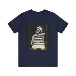 Afrocentric graphic tee shirt featuring a peaceful Black woman embracing a stack of books, symbolizing education, knowledge, freedom, and generational legacy.