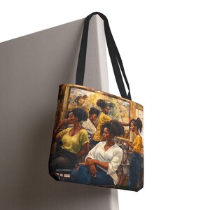 May include: A tote bag with a colorful painting of a group of women with brown skin and curly hair. The women are wearing yellow, white, and blue clothing. The painting is set in a salon with mirrors and hairdressing tools.
