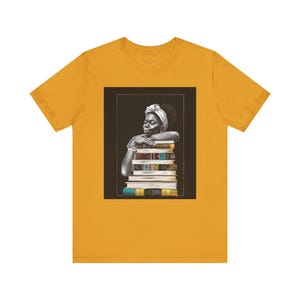 Afrocentric graphic tee shirt featuring a peaceful Black woman embracing a stack of books, symbolizing education, knowledge, freedom, and generational legacy.