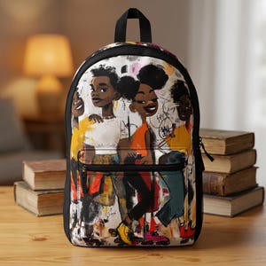 May include: A black backpack featuring a graphic print of four individuals with dark skin and textured hair wearing roller skates. The illustration uses a mix of yellow, orange, and black colors with abstract line work and graffiti-style markings.