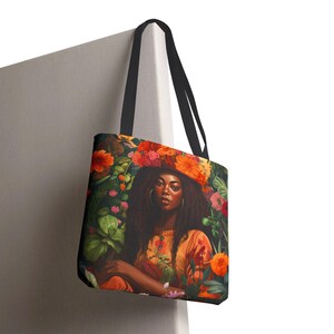Black Girl in the Garden Tote Bag featuring an Afrocentric lady surrounded by vibrant wildflowers. A stylish and durable tote perfect for garden lovers, plant enthusiasts, and everyday essentials.