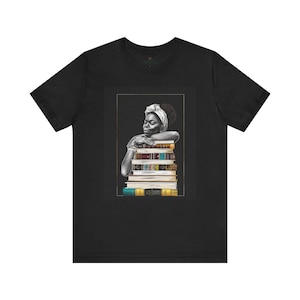 Afrocentric graphic tee shirt featuring a peaceful Black woman embracing a stack of books, symbolizing education, knowledge, freedom, and generational legacy.