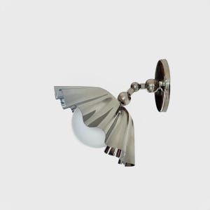 Op de afbeelding: Een moderne wandlamp met een gepolijste chromen afwerking. De armatuur heeft een decoratieve, gerimpelde kap en een bolvormige, matglazen lamp. De lamp is gemonteerd op een ronde achterplaat en heeft een verstelbare arm.