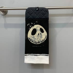 May include: Black and white kitchen towel with a graphic of Jack Skellington's face from the Nightmare Before Christmas movie. The text "Seriously Spooky" is printed below the graphic.