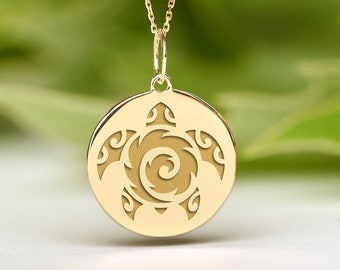 Op de afbeelding: Een gouden ketting met een ronde hanger met een gedetailleerd uitgesneden ontwerp van een zeeschildpad. De hanger is op een witte achtergrond.