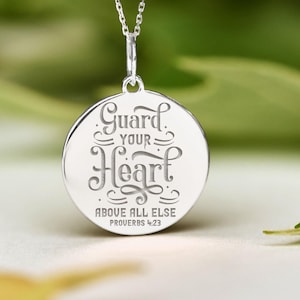 May include: Silver necklace with a round pendant that says "Guard Your Heart Above All Else Proverbs 4:23"
