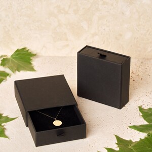 a black box with a gold necklace in it