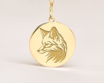May include: A gold necklace with a round pendant featuring an engraved fox head design.