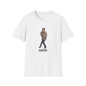 May include: White t-shirt with a photo of a man wearing a brown shirt and blue jeans. The text "SERVE" is printed below the photo.