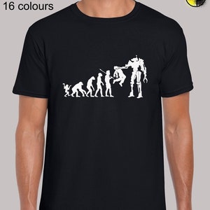 May include: A black t-shirt featuring a white graphic of the evolution of man, culminating in a robot holding the final human. The text "Sizes: S - 5XL 16 colours" is at the top of the image.